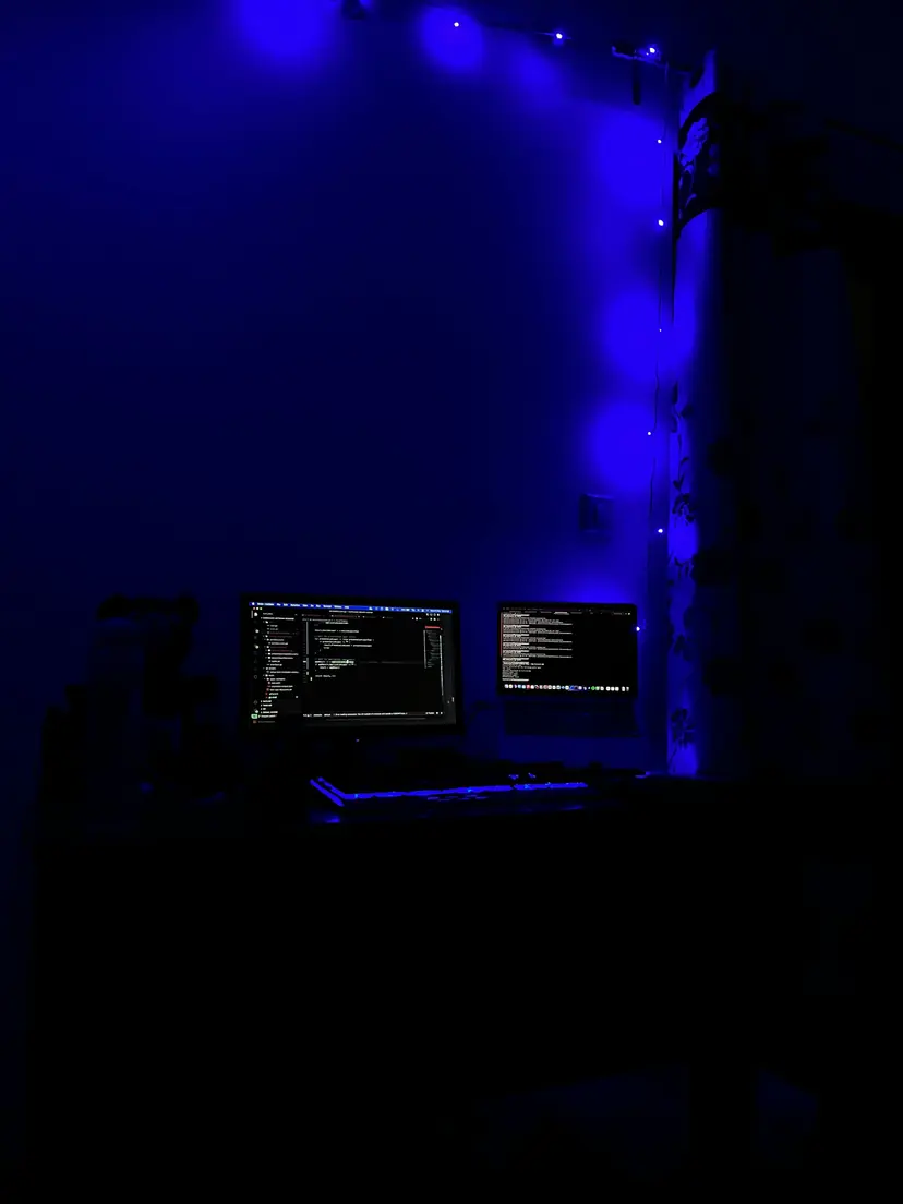 Blue-lit room with computer monitors and blue string lights